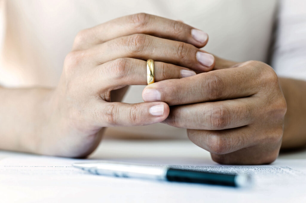 Hands of a woman who is about to take off her wedding ring