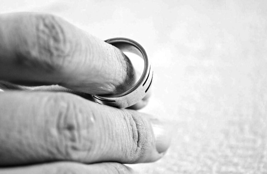 A hand of a man holding his wedding ring