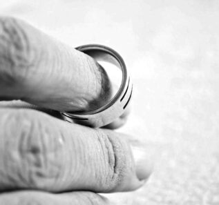 A hand of a man holding his wedding ring