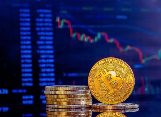 a stack of golden Bitcoin coins on a reflective dark surface with one coin standing upright displaying the Bitcoin symbol. Dividing RSUs, Cryptocurrency, and Real Estate