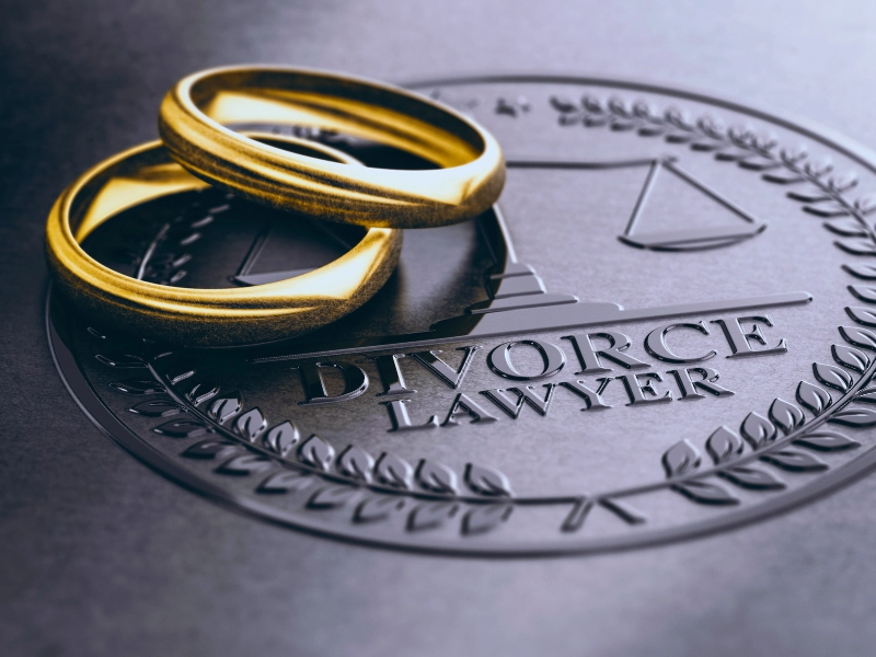Two gold wedding rings rest on a divorce lawyer seal. agree on everything for an uncontested divorce